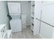 Bright laundry area with stacked washer/dryer and white shelving for optimal storage and organization at 2227 Sunset Dr # E22, Bradenton, FL 34207