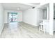 Open-concept living space with light flooring, sliding glass doors to balcony, and view of the modern kitchen at 2227 Sunset Dr # E22, Bradenton, FL 34207