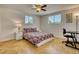 Bright bedroom featuring a desk, two windows, neutral tile flooring and a ceiling fan at 2605 Sunnybrook Dr, Sarasota, FL 34239