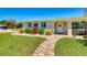 Well-maintained home with a welcoming front porch, brick pathway, and colorful flowerbeds, and lush grass at 2605 Sunnybrook Dr, Sarasota, FL 34239