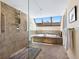 Bright bathroom showcasing a walk-in shower and soaking tub with skylight and neutral earth toned tiles at 2720 Herwald St, Sarasota, FL 34231