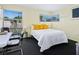 Cozy bedroom featuring yellow walls, dark carpet, and large windows offering natural light and street views at 2720 Herwald St, Sarasota, FL 34231