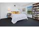 Comfortable bedroom with a white quilted bedspread, a bookshelf, and a window with natural light at 2720 Herwald St, Sarasota, FL 34231