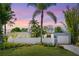 Mid-century modern home with stucco walls, mature landscaping, and sunset skies at 2720 Herwald St, Sarasota, FL 34231