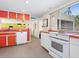 Charming kitchen with bright orange cabinets, modern appliances, and tile flooring at 2720 Herwald St, Sarasota, FL 34231