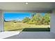 Beautiful backyard view from covered patio with lush green lawn and landscaping at 27407 Deep Creek Blvd, Punta Gorda, FL 33983