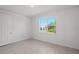 A clean bedroom features a window, tiled floors, and a white door at 27407 Deep Creek Blvd, Punta Gorda, FL 33983