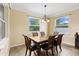 Inviting dining area featuring a wooden table, six chairs, a decorative chandelier, and natural light from two windows at 2819 130Th E Ave, Parrish, FL 34219