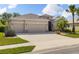 Charming home featuring a well-manicured lawn, a three-car garage, and stone accents at 2819 130Th E Ave, Parrish, FL 34219