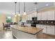 Bright kitchen with white cabinetry, granite countertops, mosaic backsplash, and stainless steel appliances at 2819 130Th E Ave, Parrish, FL 34219