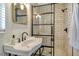 Modern bathroom featuring a stylish sink, gold mirror, and a glass-enclosed shower with subway tile at 314 28Th W St, Bradenton, FL 34205