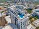 Breathtaking aerial view of a modern building showcasing rooftop pool and amenities with scenic city skyline at 33 S Palm # 1103, Sarasota, FL 34236