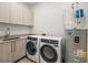 Well-lit laundry room features modern washer and dryer, sleek countertops, and ample storage space at 33 S Palm # 1103, Sarasota, FL 34236