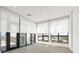 Bright, empty living room, features large windows with shades, and balcony access at 33 S Palm # 1103, Sarasota, FL 34236