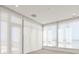 Bright, empty living room, features large windows with blinds, and balcony access at 33 S Palm # 1103, Sarasota, FL 34236