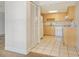 Functional kitchen with light wood cabinets, tile flooring, and essential appliances at 3403 Clark Rd # 203, Sarasota, FL 34231