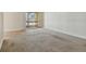 Spacious living room with sliding glass doors to a private balcony and carpeted floors at 3403 Clark Rd # 203, Sarasota, FL 34231