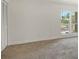 Comfortable living area with access to a storage closet and view of palm trees through bright windows at 3403 Clark Rd # 203, Sarasota, FL 34231