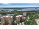 Aerial view of condo buildings, a pool, and lush landscaping by the water at 3621 North Point Rd # 603, Osprey, FL 34229