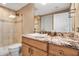 Bathroom featuring granite counters, wood cabinetry, walk-in shower with tiled walls and glass door at 3621 North Point Rd # 603, Osprey, FL 34229