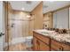 Bathroom featuring a wood cabinet, granite counter, and tiled walk-in shower with glass enclosure at 3621 North Point Rd # 603, Osprey, FL 34229