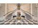 Impressive foyer with a grand staircase, exquisite chandelier, and elegant black-and-white tile flooring at 3621 North Point Rd # 603, Osprey, FL 34229
