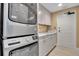 Modern laundry room boasts a stackable washer/dryer, shaker cabinets, and updated finishes for added convenience at 3621 North Point Rd # 603, Osprey, FL 34229