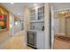 Wet bar in hallway featuring white cabinets, bar fridge and counter at 3621 North Point Rd # 603, Osprey, FL 34229