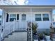 Charming single-story home featuring an inviting front porch with white railings and well-maintained landscaping at 3710 Gulf Of Mexico Dr # E22, Longboat Key, FL 34228