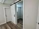 Hallway featuring light walls, wood floors, and a doorway with barn door at 3710 Gulf Of Mexico Dr # E22, Longboat Key, FL 34228