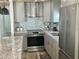 A modern kitchen features stainless steel appliances, granite countertops, and a stylish backsplash at 3710 Gulf Of Mexico Dr # E22, Longboat Key, FL 34228