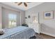 Well-lit bedroom featuring wood floors, ceiling fan, and stylish white dresser at 3921 Waypoint Ave, Osprey, FL 34229
