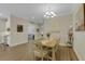 Elegant dining area with a wooden table, white chairs, chandelier, and a view of the living area beyond at 3921 Waypoint Ave, Osprey, FL 34229