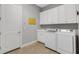 Functional laundry room with modern washer and dryer units, sink, cabinets, and tile flooring at 3921 Waypoint Ave, Osprey, FL 34229