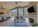 Inviting outdoor living area with fireplace, tv, comfortable seating and dining overlooking the pool and backyard at 3921 Waypoint Ave, Osprey, FL 34229