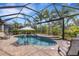 Screened-in pool area with a beautiful in-ground pool, jacuzzi, and lovely brick patio surrounded by green landscaping at 3921 Waypoint Ave, Osprey, FL 34229