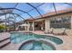 A resort-style pool includes a spa, tanning ledge, and covered patio with grill and dining area at 3921 Waypoint Ave, Osprey, FL 34229