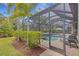 Screened-in pool area features a refreshing pool, spa, patio furniture, and lush landscaping at 3921 Waypoint Ave, Osprey, FL 34229