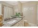 Bright bathroom featuring granite countertop and beach themed decorations at 3954 Wilshire Cir # 165, Sarasota, FL 34238