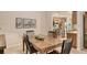 Dining room with wood table, chairs, art, and view of kitchen at 3954 Wilshire Cir # 165, Sarasota, FL 34238