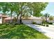 Inviting single-story home with a two-car garage, a well-manicured lawn, mature trees, and lush landscaping at 3954 Wilshire Cir # 165, Sarasota, FL 34238