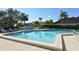 Sparkling pool with lounge chairs, lush landscaping, and clear blue skies at 3954 Wilshire Cir # 165, Sarasota, FL 34238