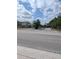 Community entrance with black gate, shrubs, palm trees and blue skies with white clouds at 4707 1St E Ave # 4707, Palmetto, FL 34221
