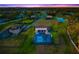 Aerial view of the neighborhood, home, and screened-in pool, overlooking the pristine landscaping and pond at 4712 Margutta Ct, Sarasota, FL 34240