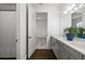Bright bathroom features a double vanity, wood look tile floor, and an open doorway to another room at 4712 Margutta Ct, Sarasota, FL 34240