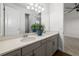 Bathroom featuring a double vanity with gray cabinets, and an open door to the bedroom at 4712 Margutta Ct, Sarasota, FL 34240
