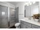 Contemporary bathroom with gray tiled walk-in shower, glass enclosure, and white vanity at 4712 Margutta Ct, Sarasota, FL 34240