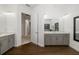 Expansive bathroom with wood-look floors, grey vanity, and dual mirrors at 4712 Margutta Ct, Sarasota, FL 34240