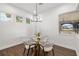 Bright breakfast nook features modern chandelier, wood-look floors and windows overlooking exterior living space at 4712 Margutta Ct, Sarasota, FL 34240