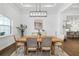 Bright dining room with modern chandelier, neutral paint, and an eye-catching piece of artwork at 4712 Margutta Ct, Sarasota, FL 34240